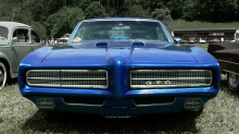 Взгляд спереди на синий Pontiac GTO крупным планом среди ретро авто